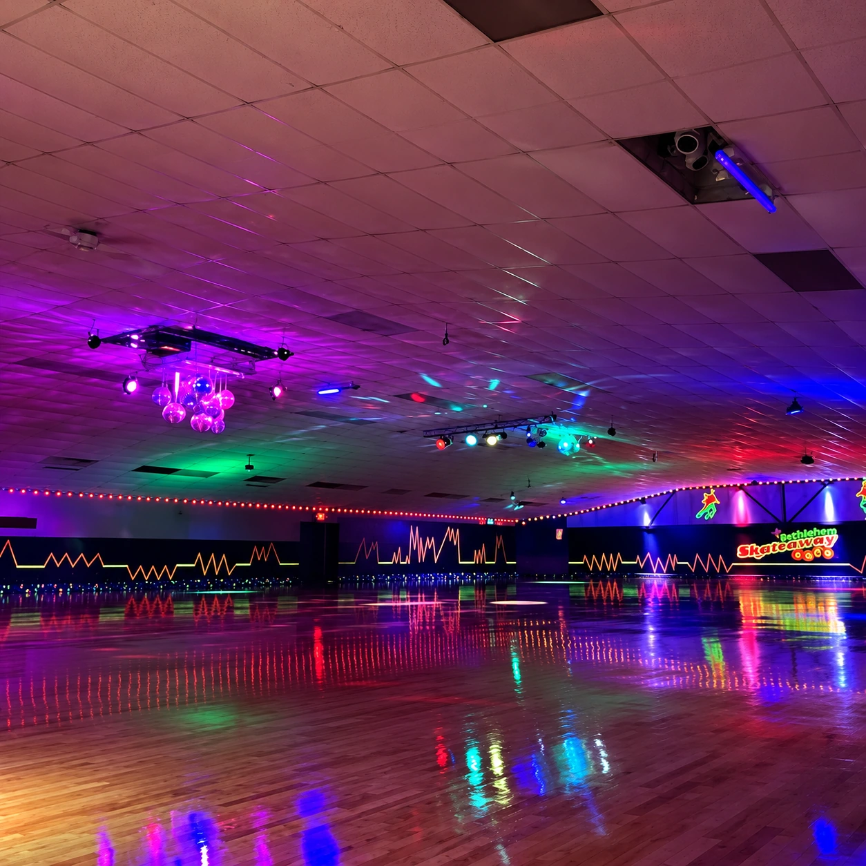 Bethlehem Skateaway’s skating floor under colorful lights, enhanced from the original rink photo