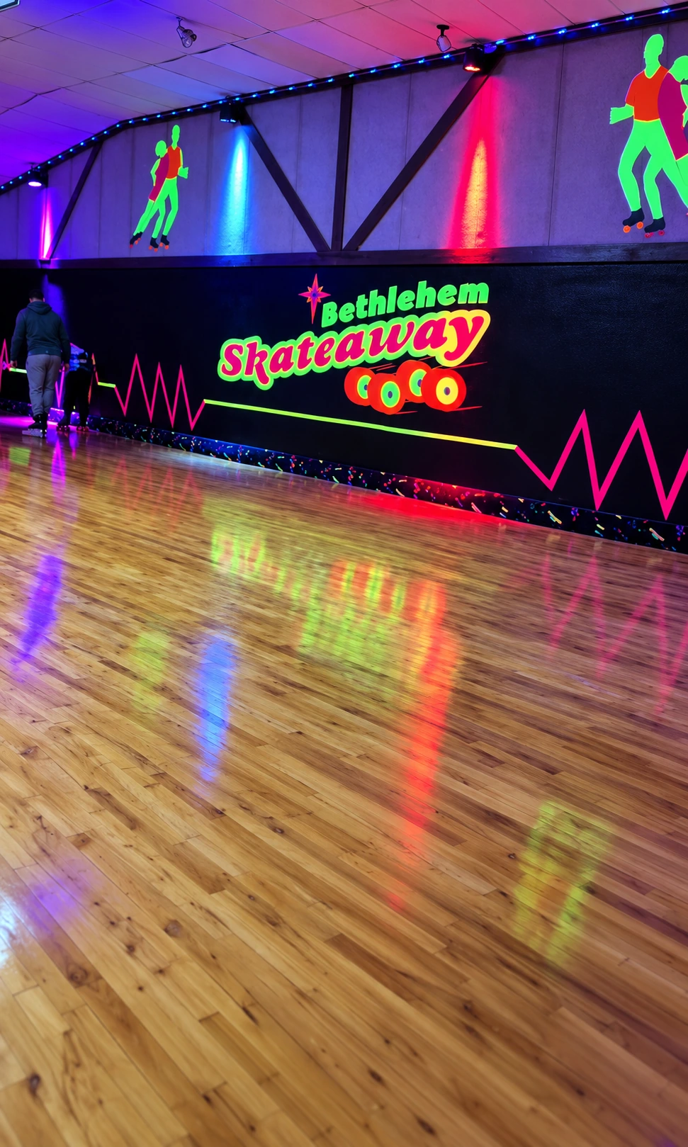 Enhanced photo of Bethlehem Skateaway’s neon wall artwork and wood skating floor